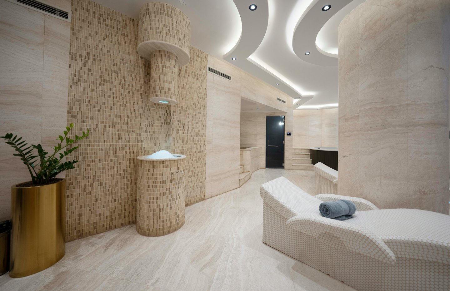 Two white lounge chairs sit inside a modern luxury spa.