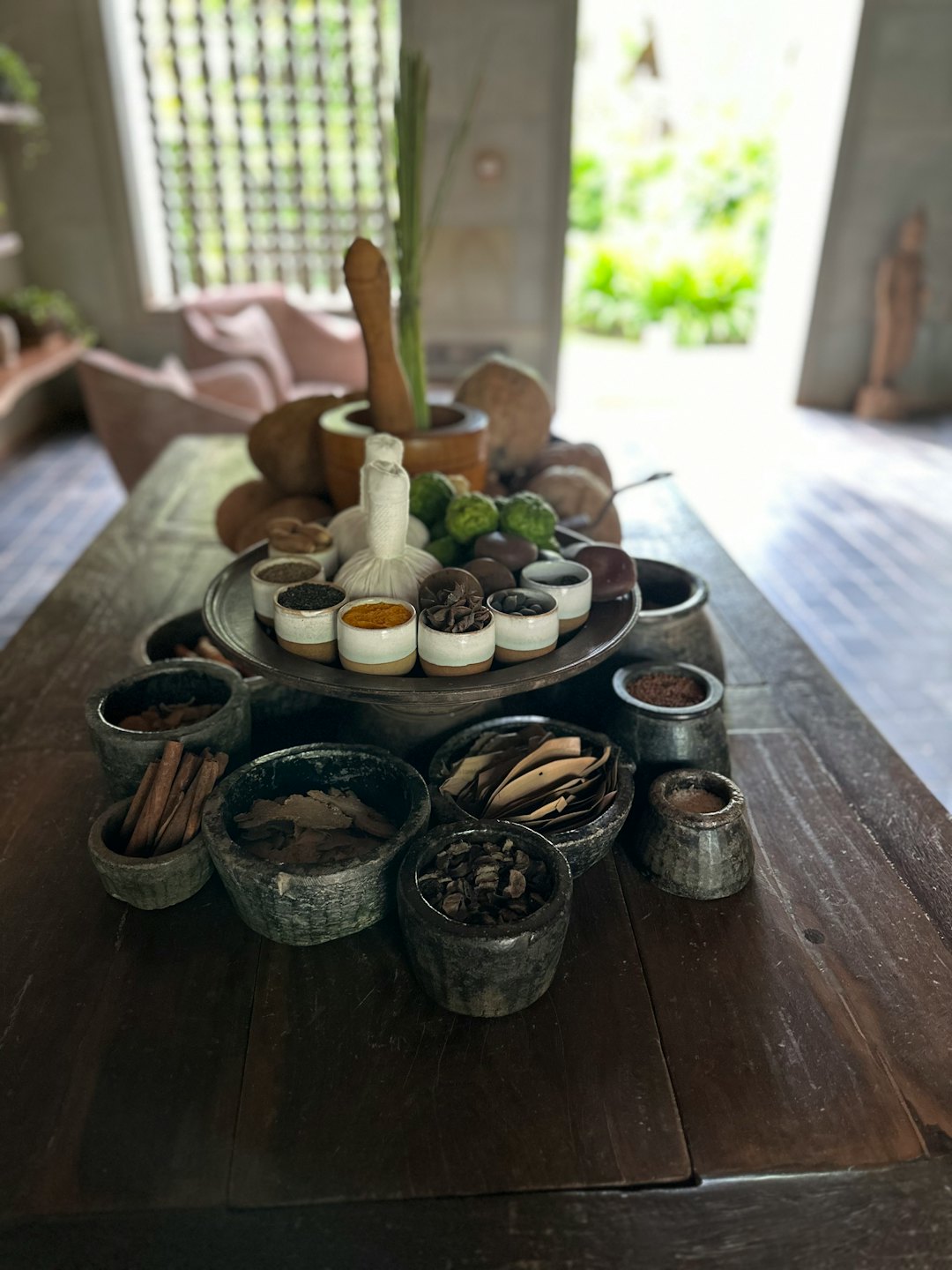 Natural spa ingredients and herbal compresses arranged on a wooden table.